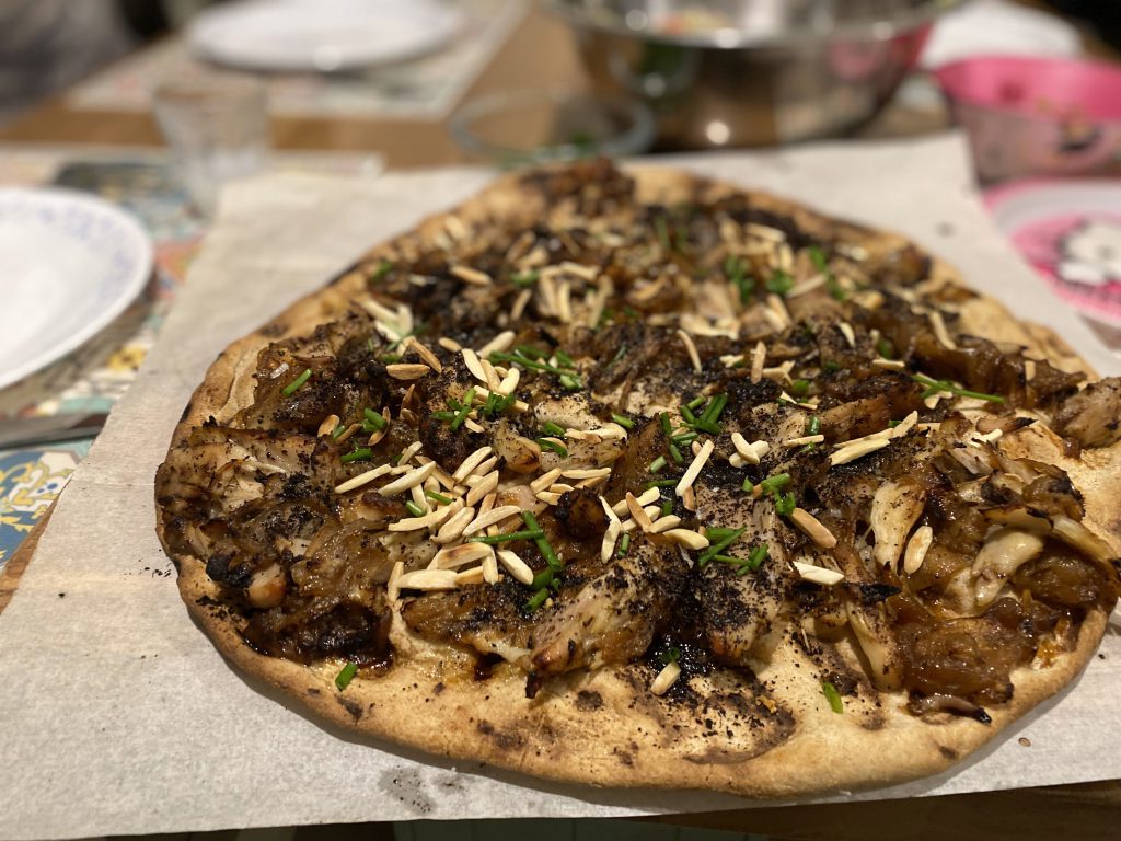 Musakhan: Roasted chicken with sumac, caramelized onions, and pine nuts, served on a flatbread.